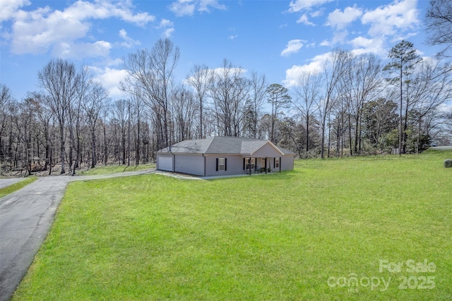 view of front of house with a garage, driveway, and a front lawn