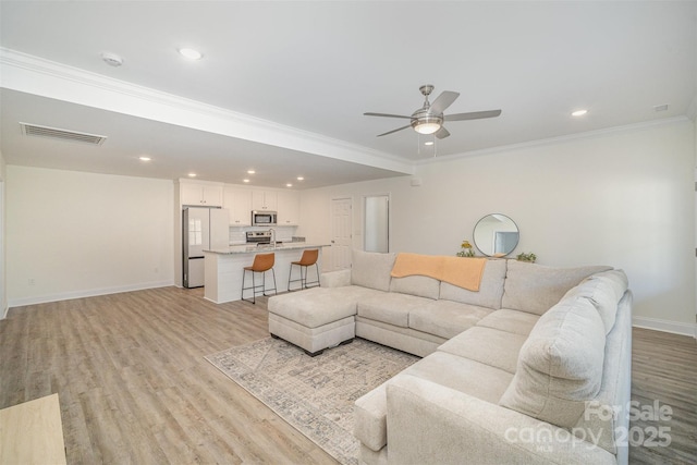 living area with crown molding, recessed lighting, visible vents, light wood-type flooring, and baseboards