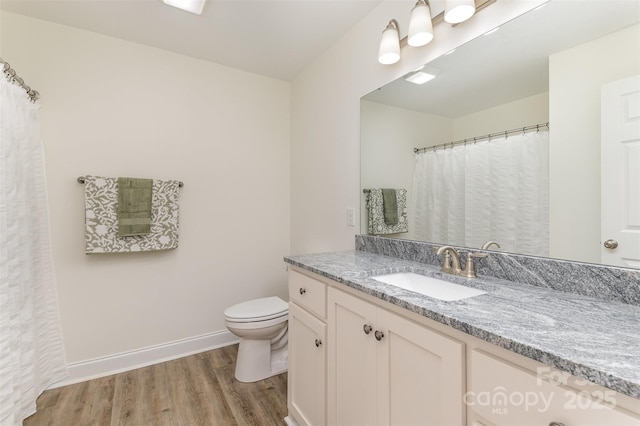 full bathroom with toilet, baseboards, wood finished floors, and vanity