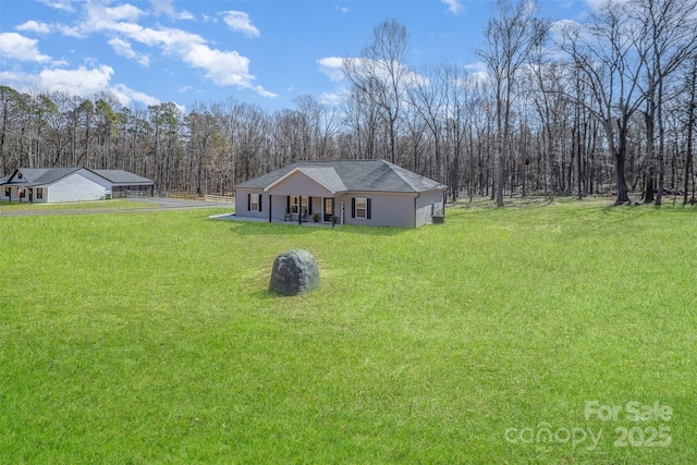 view of front of home with roof with shingles, a porch, and a front yard