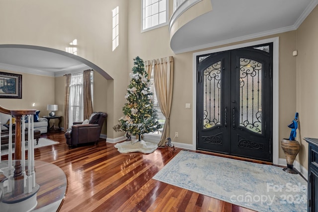 foyer with french doors, hardwood / wood-style flooring, and crown molding