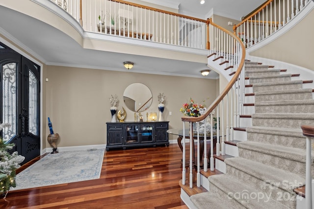 foyer featuring french doors, crown molding, a wealth of natural light, and dark wood-type flooring