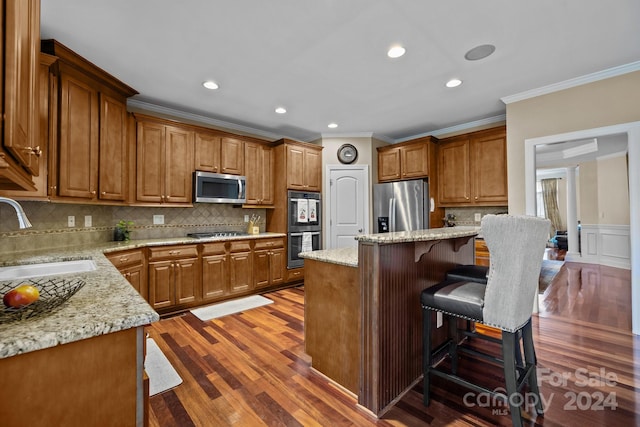 kitchen featuring sink, a center island, stainless steel appliances, tasteful backsplash, and dark hardwood / wood-style floors