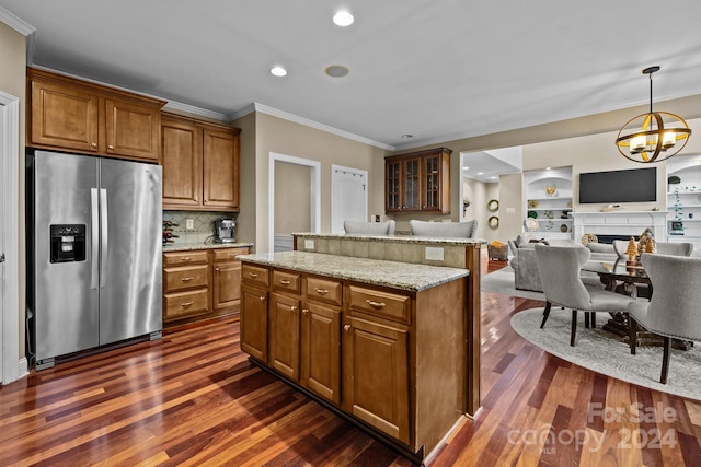 kitchen with backsplash, dark hardwood / wood-style floors, light stone countertops, a notable chandelier, and stainless steel fridge with ice dispenser