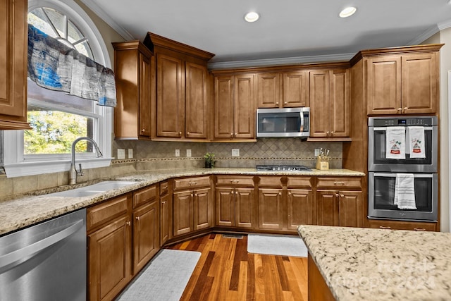 kitchen featuring sink, stainless steel appliances, dark hardwood / wood-style floors, crown molding, and decorative backsplash