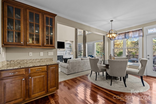 dining space with dark hardwood / wood-style floors, an inviting chandelier, and crown molding