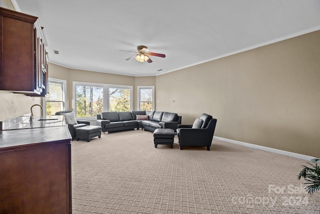 carpeted living room with crown molding and ceiling fan