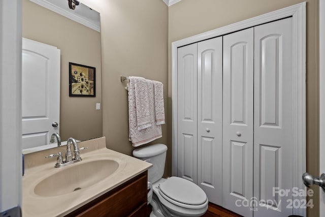 bathroom with vanity, toilet, and ornamental molding