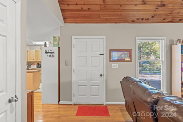 entryway with light hardwood / wood-style floors and wood ceiling