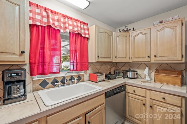 kitchen with sink, tasteful backsplash, light brown cabinetry, tile counters, and dishwasher