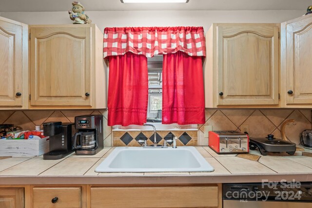 kitchen featuring light brown cabinets, tile countertops, and sink