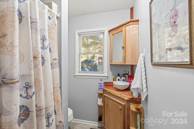 bathroom with toilet, vanity, and curtained shower