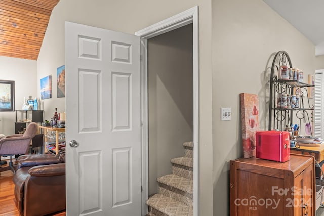 staircase featuring hardwood / wood-style floors, wood ceiling, and vaulted ceiling