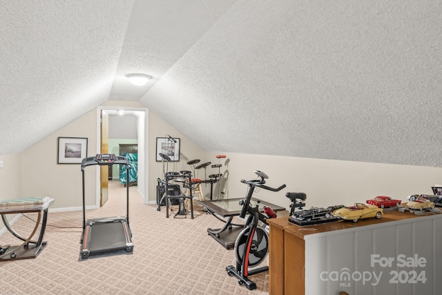 exercise room featuring a textured ceiling, lofted ceiling, and carpet floors