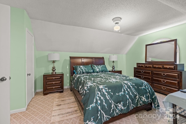 carpeted bedroom featuring vaulted ceiling and a textured ceiling