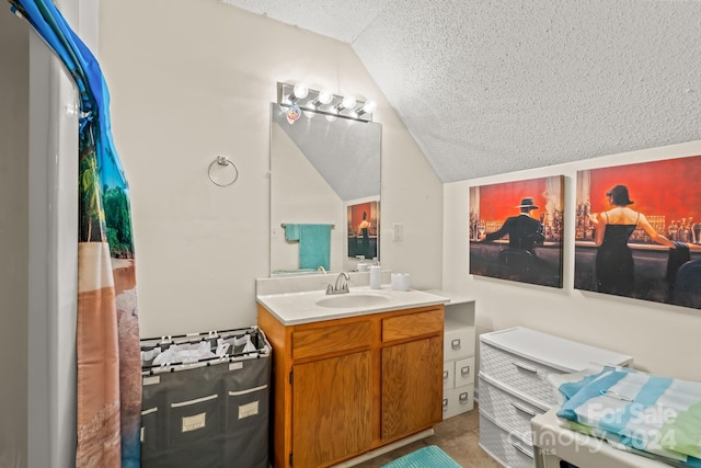 bathroom featuring vanity, a textured ceiling, and vaulted ceiling