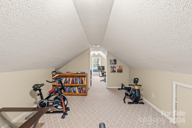 workout area featuring vaulted ceiling, light colored carpet, and a textured ceiling