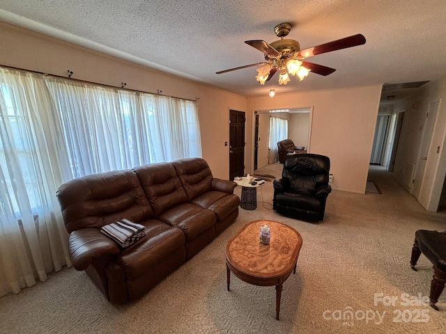 carpeted living room with ceiling fan and a textured ceiling