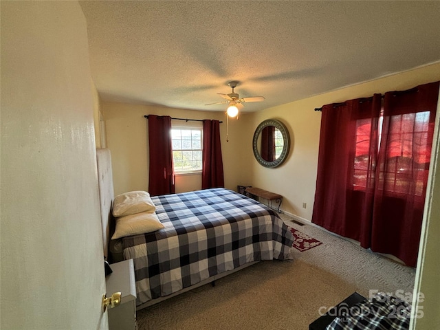 carpeted bedroom with a textured ceiling and ceiling fan