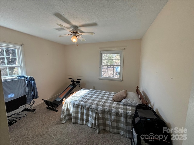 bedroom featuring ceiling fan, carpet, and a textured ceiling