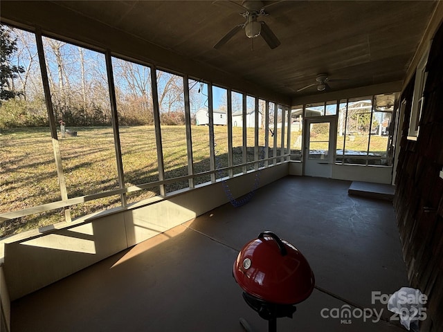 unfurnished sunroom with ceiling fan