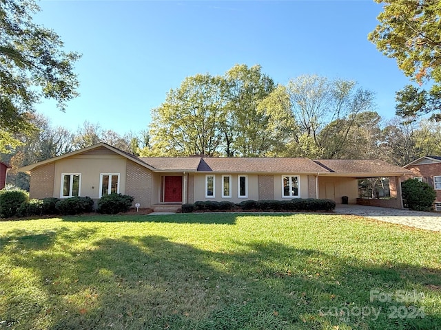 ranch-style house featuring a front lawn and a carport