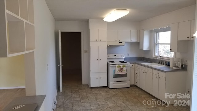 kitchen featuring electric range, sink, and white cabinets