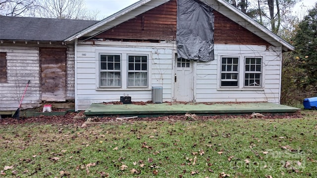 rear view of property featuring a lawn