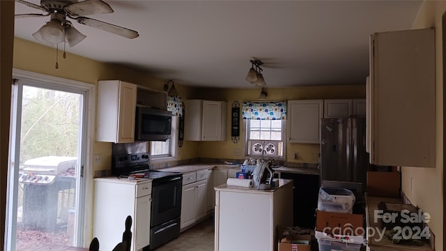 kitchen with white cabinets, black range with electric stovetop, ceiling fan, and a kitchen island