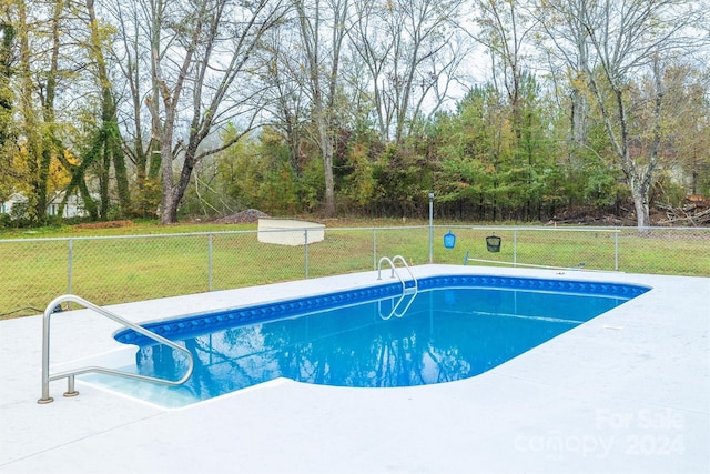 view of pool with a lawn