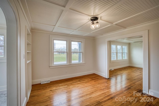 unfurnished room featuring light hardwood / wood-style floors, a wealth of natural light, and ornamental molding