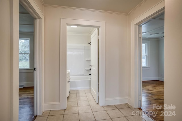 hall featuring ornamental molding and light hardwood / wood-style floors