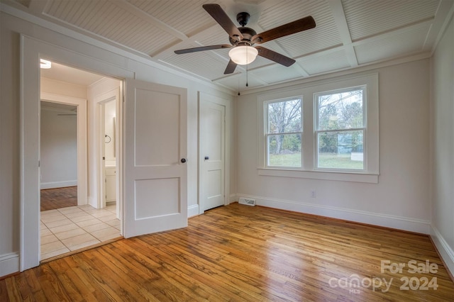 unfurnished bedroom with ornamental molding, light hardwood / wood-style floors, ceiling fan, and beam ceiling