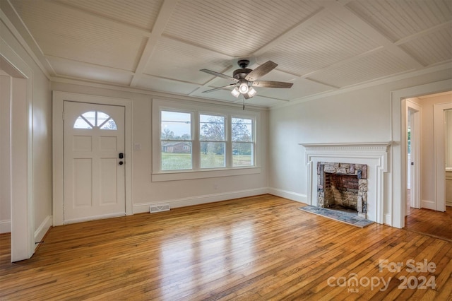 unfurnished living room featuring a wealth of natural light, ceiling fan, light wood-type flooring, and coffered ceiling