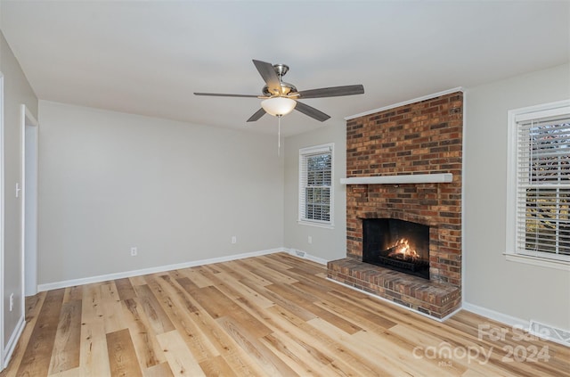 unfurnished living room with a fireplace, ceiling fan, and light hardwood / wood-style flooring