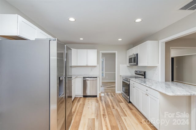 kitchen featuring white cabinetry, appliances with stainless steel finishes, light stone counters, and light hardwood / wood-style flooring