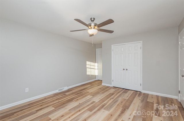 unfurnished bedroom with ceiling fan, a closet, and light hardwood / wood-style flooring