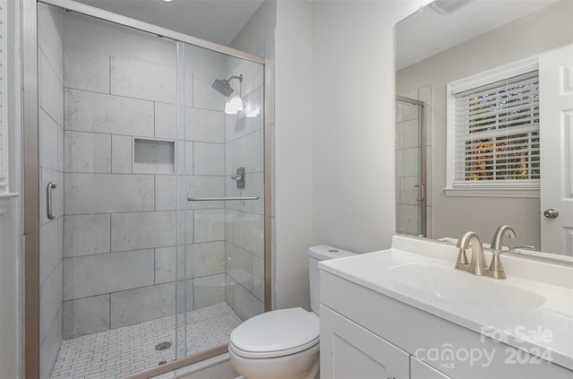 bathroom featuring walk in shower, vanity, and toilet