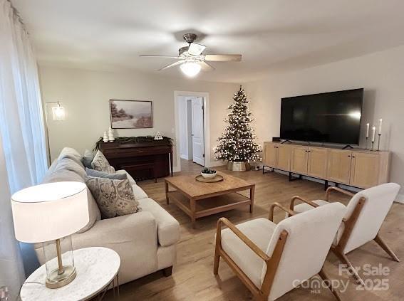 living room featuring light wood-type flooring and ceiling fan