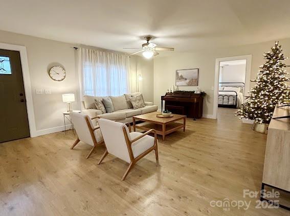 living room with light hardwood / wood-style flooring and ceiling fan