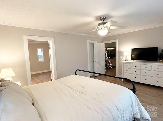 bedroom with wood-type flooring, ensuite bath, ceiling fan, and crown molding