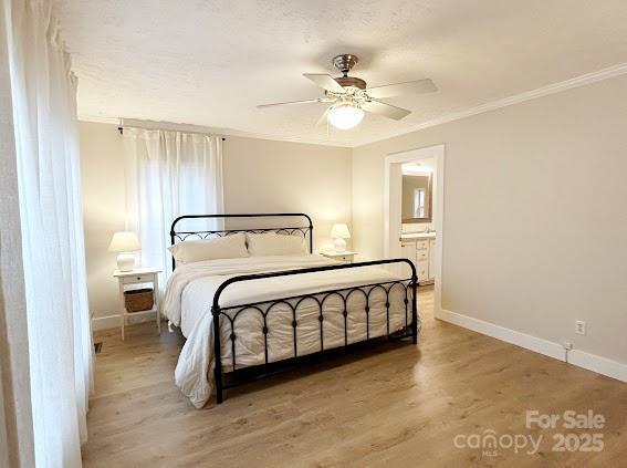 bedroom featuring connected bathroom, ceiling fan, crown molding, and wood-type flooring