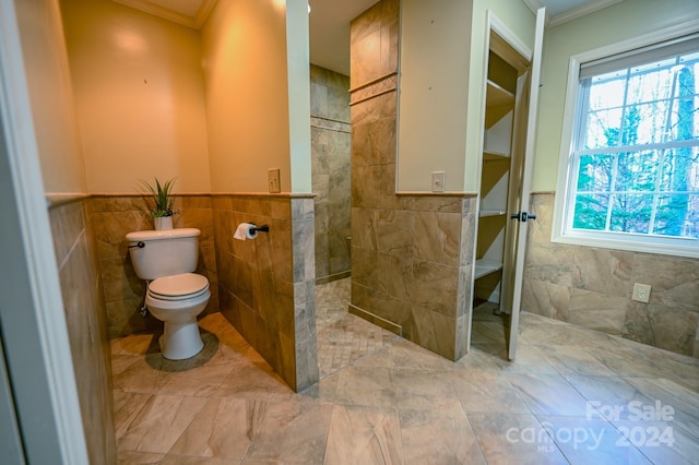 bathroom featuring toilet, tile walls, and ornamental molding