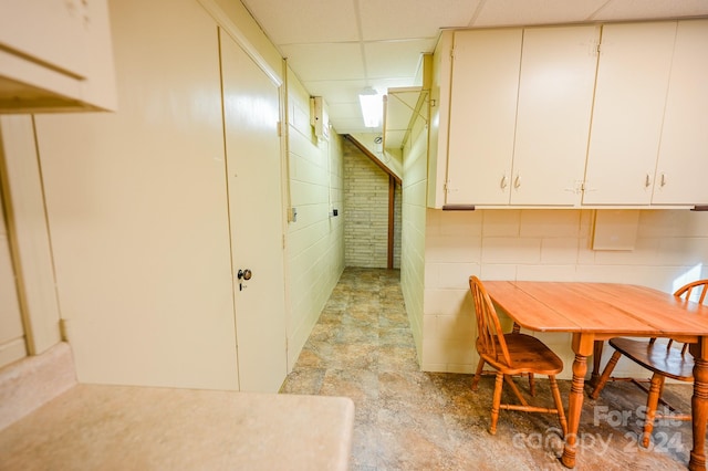 interior space featuring white cabinets and a paneled ceiling