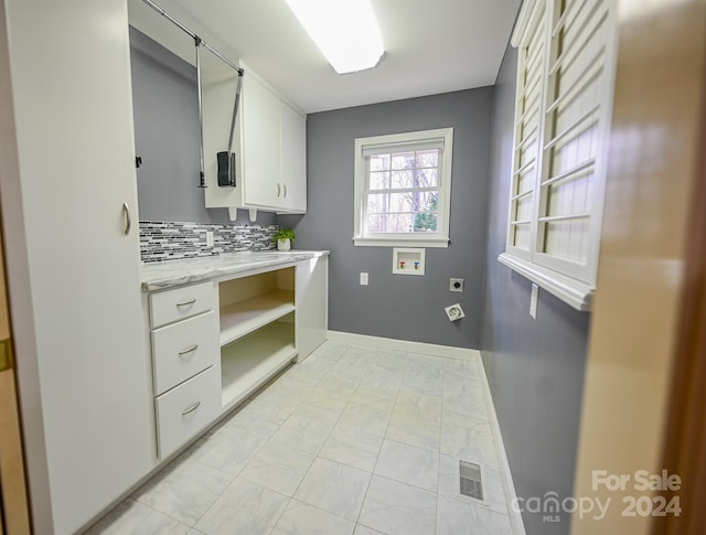 clothes washing area featuring cabinets, hookup for a washing machine, and electric dryer hookup