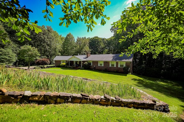 183 Creekside Dr, Forest City, NC 28043 - ranch-style home with a front lawn, a chimney, and brick siding