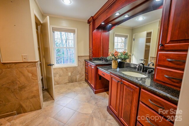 183 Creekside Dr, Forest City, NC 28043 - bathroom with ornamental molding, tile walls, marble finish flooring, double vanity, and a wainscoted wall