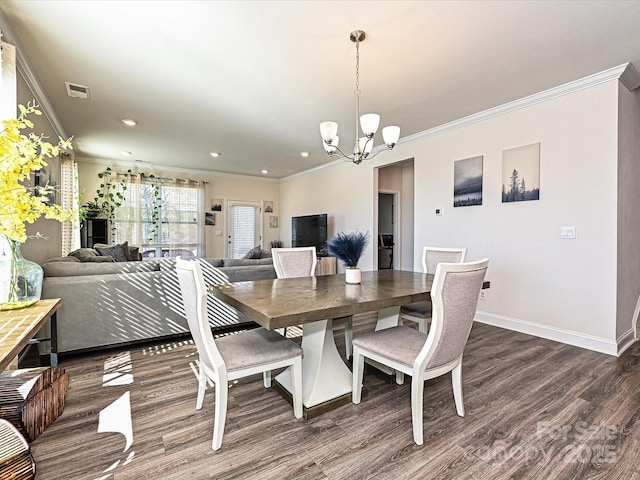 dining space with ornamental molding, dark wood-type flooring, and a notable chandelier