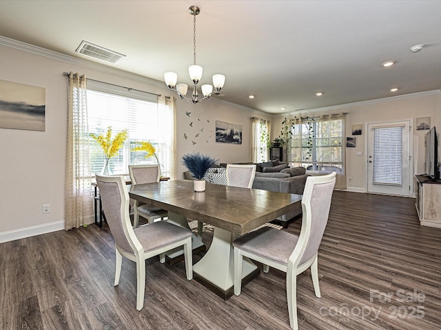 dining area featuring a healthy amount of sunlight, ornamental molding, dark wood-type flooring, and an inviting chandelier