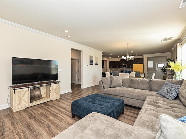 living room featuring ornamental molding, dark hardwood / wood-style floors, and a notable chandelier